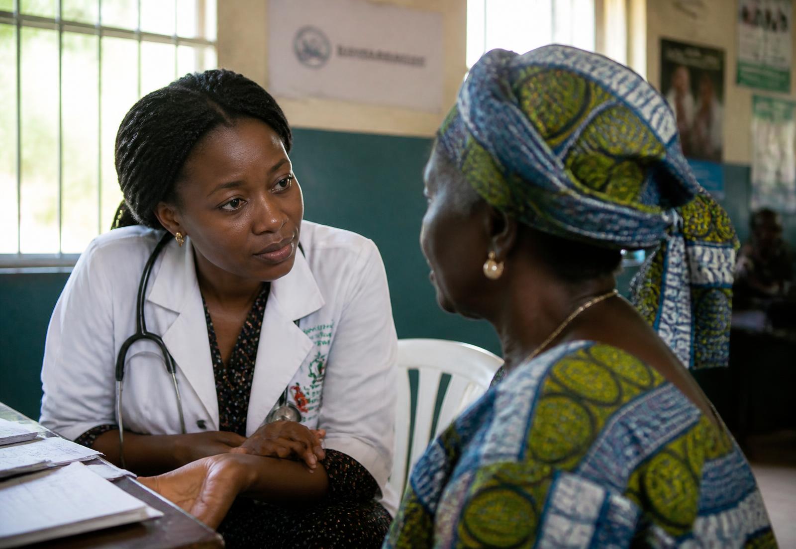 A doctor at Savannah Wellness Center leaning in to listen carefully to a patient in a sunlit consulting room